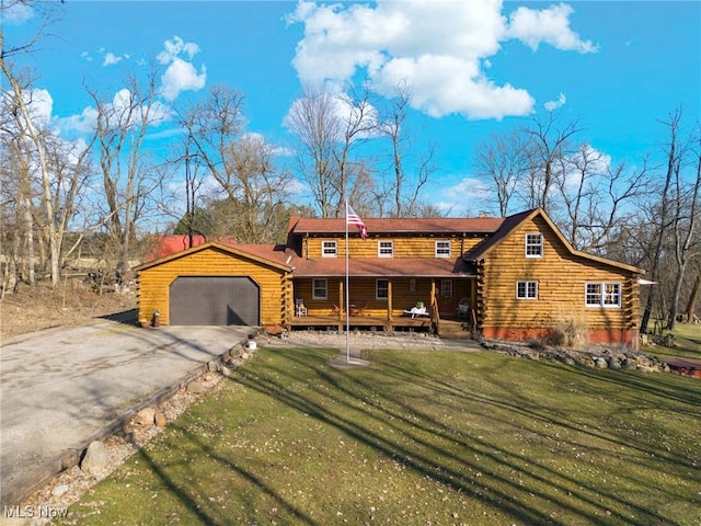 cabin featuring an attached garage, a front lawn, log siding, and aphalt driveway
