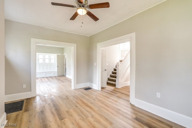 unfurnished room with light wood-style floors, visible vents, and baseboards