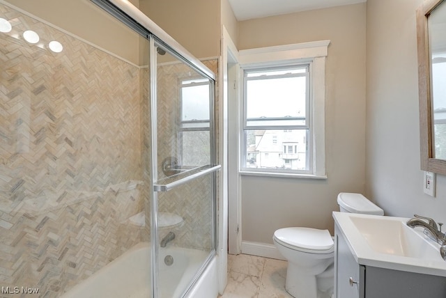 full bath featuring vanity, marble finish floor, bath / shower combo with glass door, baseboards, and toilet