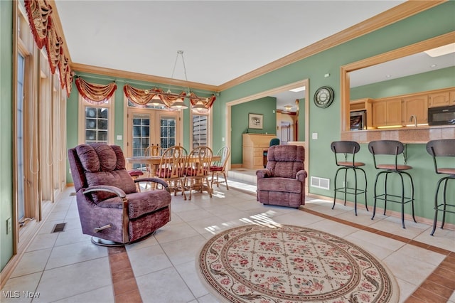 living room featuring ornamental molding, baseboards, visible vents, and light tile patterned floors