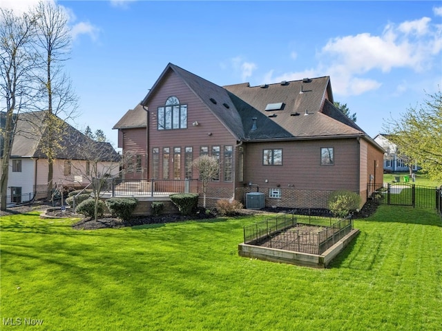 rear view of property featuring a vegetable garden, fence, central air condition unit, a lawn, and brick siding