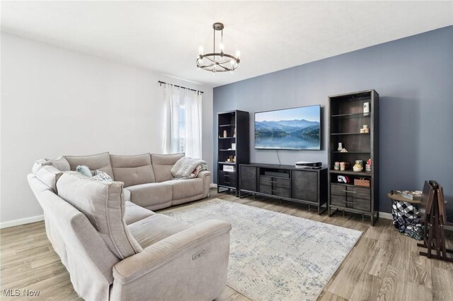 living area with an inviting chandelier, wood finished floors, and baseboards