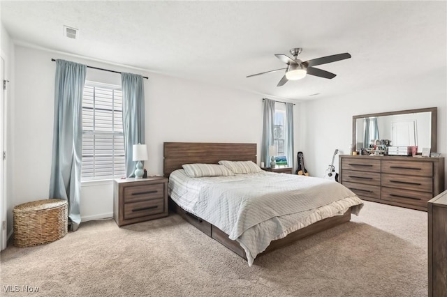 bedroom with ceiling fan, carpet floors, multiple windows, and visible vents
