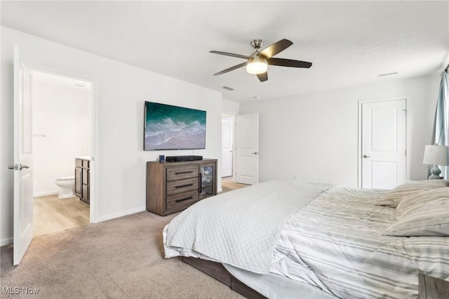 bedroom with baseboards, visible vents, light colored carpet, a ceiling fan, and connected bathroom