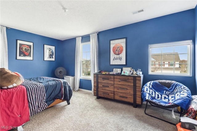 carpeted bedroom featuring visible vents and multiple windows