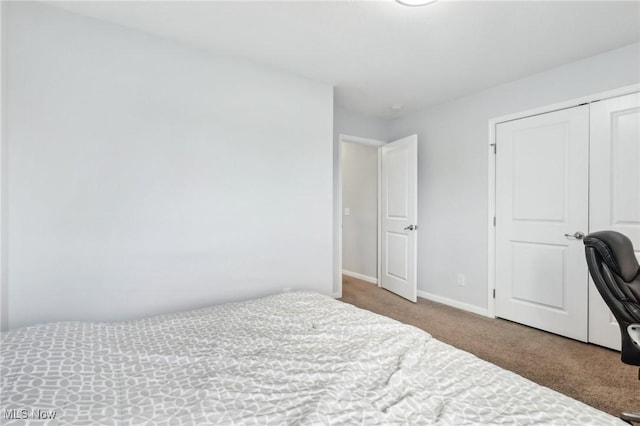 carpeted bedroom featuring baseboards and a closet