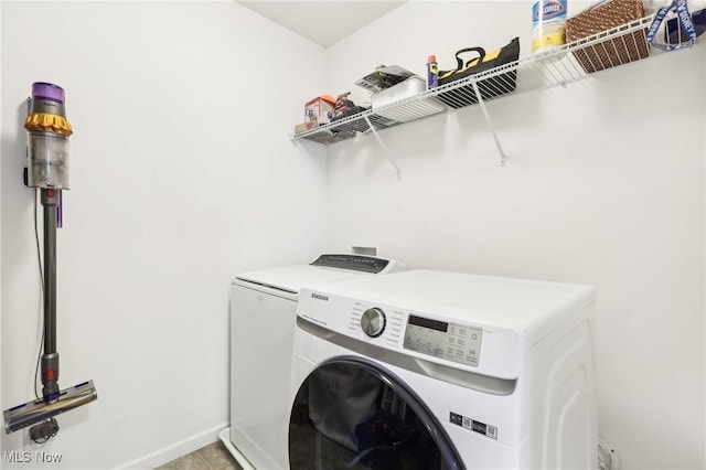 laundry area featuring light tile patterned floors, baseboards, washer and dryer, and laundry area