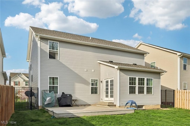 back of house featuring a gate, a fenced backyard, entry steps, a yard, and a wooden deck