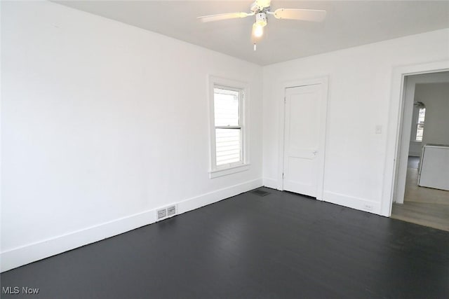 unfurnished bedroom featuring visible vents, a ceiling fan, baseboards, and dark wood finished floors