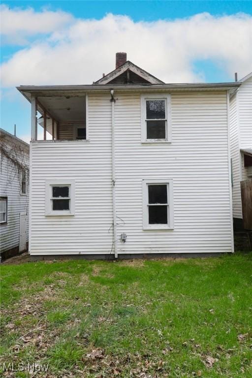 rear view of property with a lawn