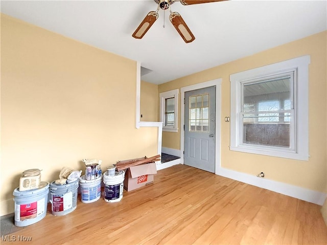 foyer entrance with wood finished floors, baseboards, and ceiling fan