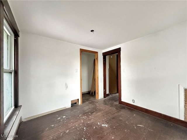 empty room featuring a healthy amount of sunlight, baseboards, and baseboard heating