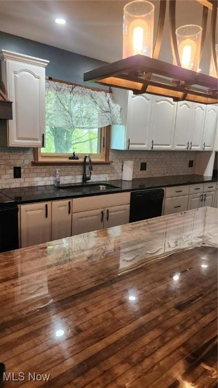 kitchen with white cabinets, backsplash, dishwasher, and a sink
