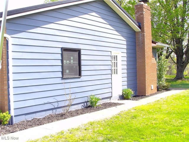 view of home's exterior featuring a yard and a chimney