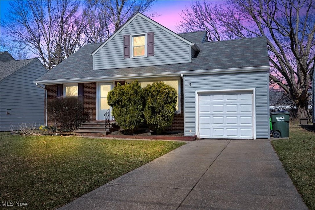 320 Walworth Ave, Euclid, OH 44132 - view of front of house featuring brick siding, a yard, an attached garage, and driveway