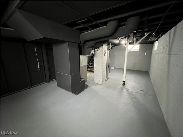 below grade area featuring stairs and heating unit