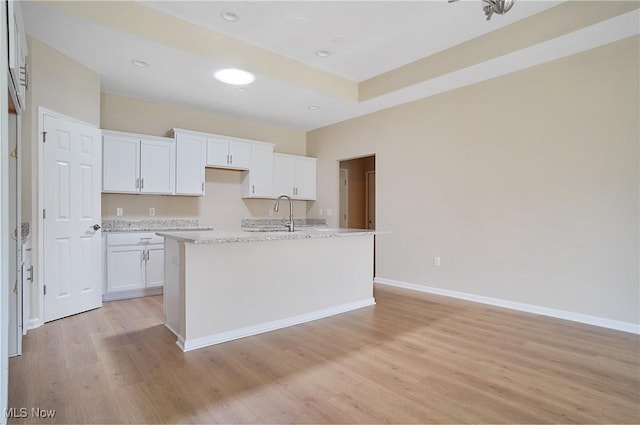 9264 Sharrott Rd Unit 1002, Poland, OH 44514 - kitchen with white cabinets, light wood-type flooring, an island with sink, light stone counters, and recessed lighting