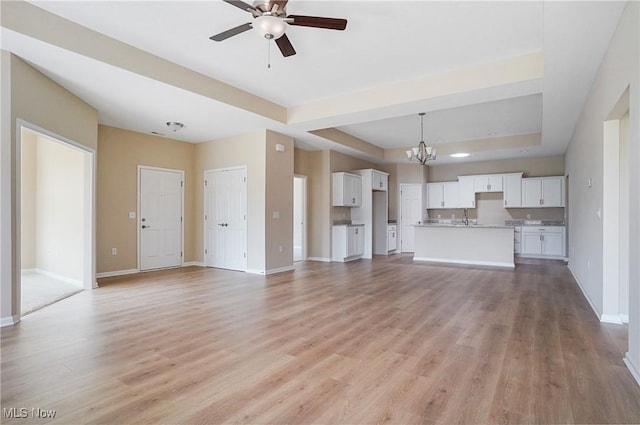 9264 Sharrott Rd Unit 1002, Poland, OH 44514 - unfurnished living room with a chandelier, a raised ceiling, light wood-style flooring, ceiling fan, and recessed lighting