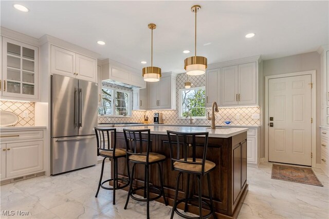 2622 Glenmont Rd NW, Canton, OH 44708 - kitchen with plenty of natural light, light countertops, freestanding refrigerator, and decorative backsplash