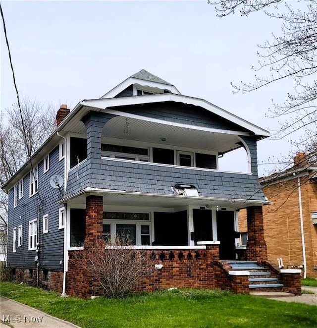view of front of home featuring a chimney, a porch, and a balcony