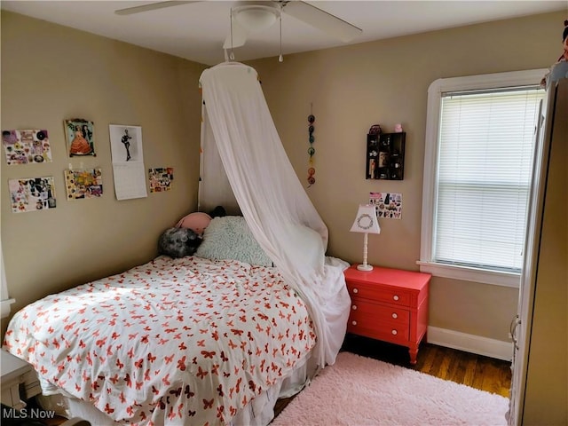bedroom with baseboards, a ceiling fan, and wood finished floors