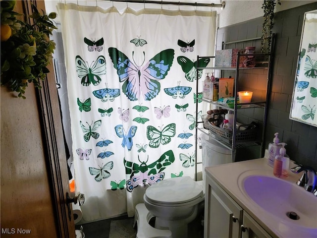 bathroom featuring shower / bath combination with curtain, vanity, and toilet