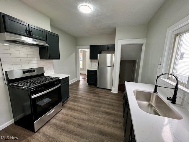 3478 E 150th St, Cleveland, OH 44120 - kitchen with a sink, dark wood finished floors, tasteful backsplash, under cabinet range hood, and appliances with stainless steel finishes