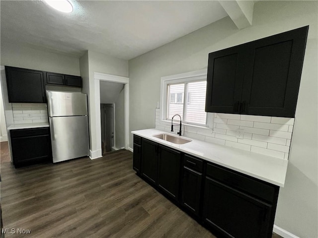 3478 E 150th St, Cleveland, OH 44120 - kitchen with a sink, decorative backsplash, dark cabinetry, light countertops, and freestanding refrigerator