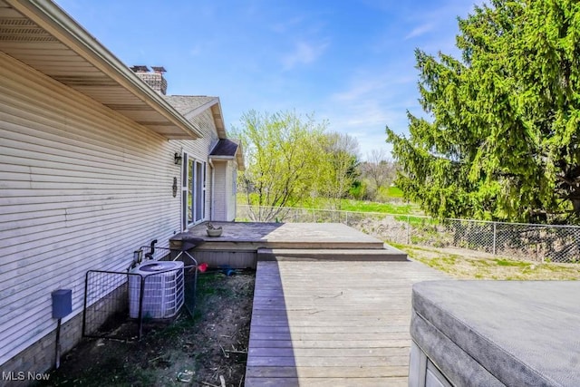 wooden terrace featuring central air condition unit and a fenced backyard