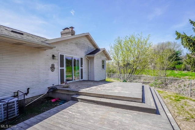 wooden terrace featuring central air condition unit and fence