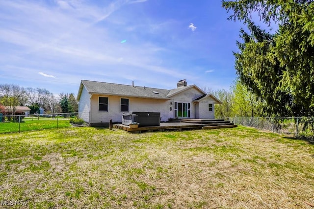 rear view of property with a wooden deck, a yard, a hot tub, and a fenced backyard