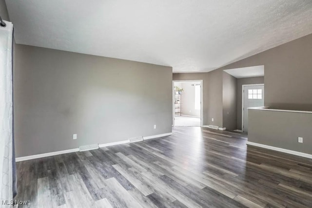 empty room featuring dark wood-type flooring and baseboards