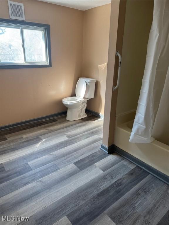 625 Allyn St, Akron, OH 44311 - full bathroom featuring wood finished floors, visible vents, baseboards, toilet, and shower / bath combo with shower curtain