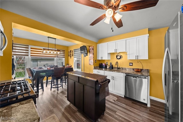 kitchen featuring ceiling fan, white cabinetry, stainless steel appliances, and a sink