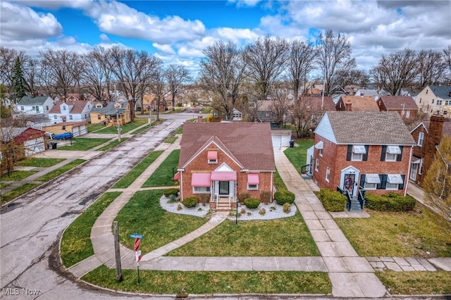view of front facade featuring brick siding, a residential view, and a front lawn