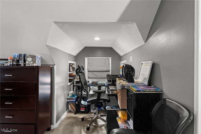 carpeted office space with lofted ceiling and baseboards