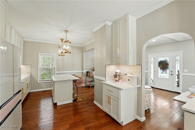 3270 S Canfield Niles Rd, Canfield, OH 44406 - kitchen with dark wood-style floors, arched walkways, a kitchen bar, decorative backsplash, and light countertops