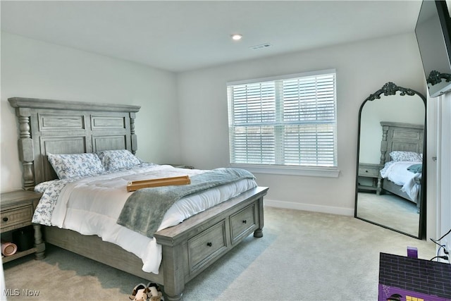 bedroom with visible vents, baseboards, and light carpet