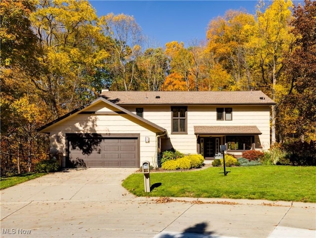 view of front of home with an attached garage, driveway, and a front yard