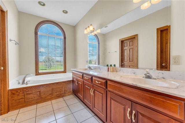 bathroom with tile patterned flooring, a garden tub, a sink, and double vanity