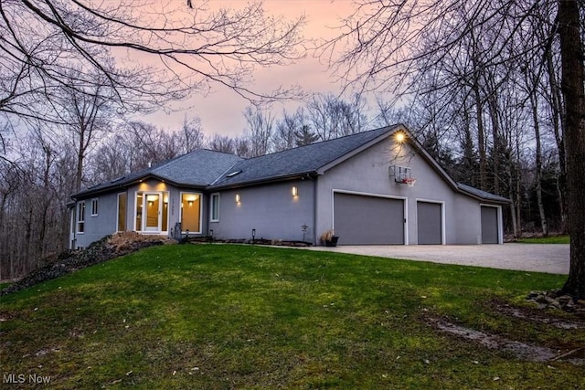 view of front of home with stucco siding, dirt driveway, a front lawn, and an attached garage