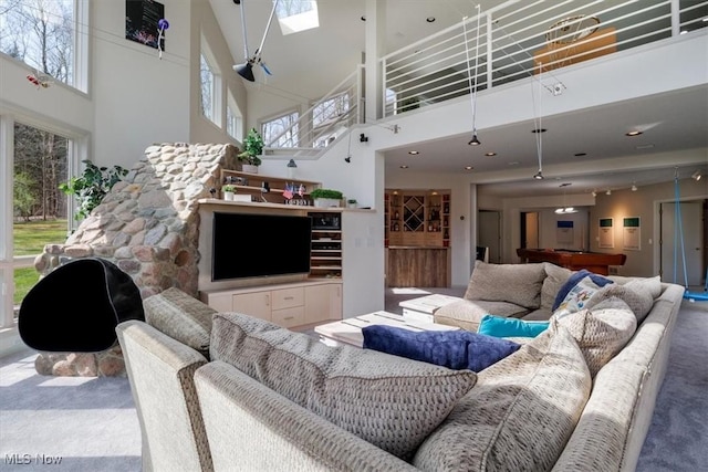 carpeted living area featuring a high ceiling, a skylight, and billiards table