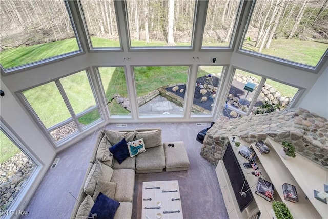 sunroom with a towering ceiling and carpet floors