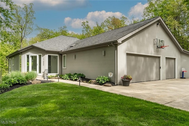 view of front of house featuring concrete driveway, a front yard, stucco siding, and a garage