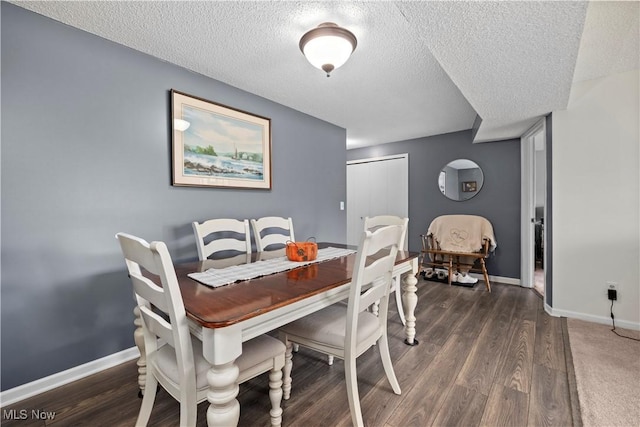 dining area with wood finished floors, baseboards, and a textured ceiling