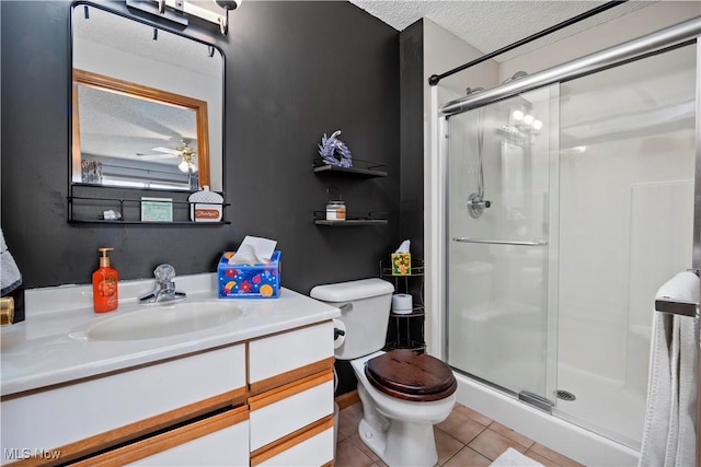 full bath featuring a shower stall, tile patterned floors, toilet, vanity, and a textured ceiling