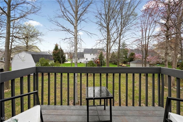deck with a yard, an outbuilding, a shed, and a residential view