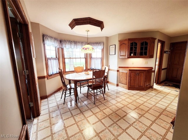 dining room featuring baseboards and a textured ceiling