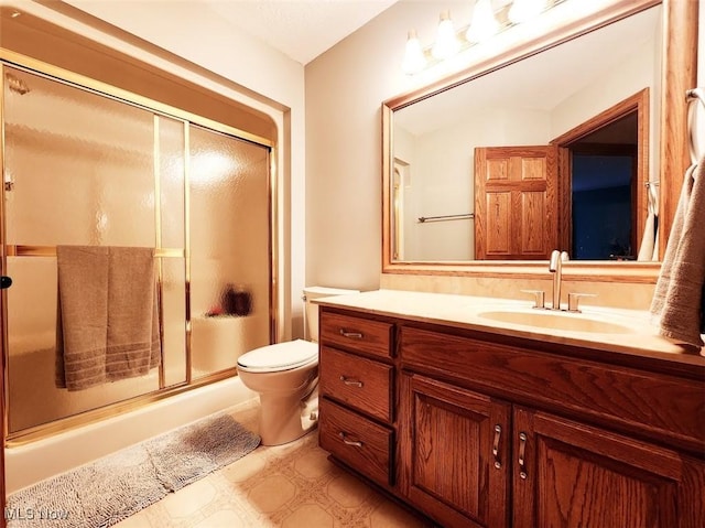 bathroom with vanity, a shower with shower door, and toilet