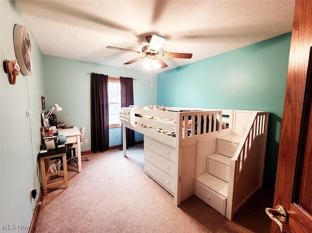 bedroom featuring light colored carpet, a ceiling fan, and a textured ceiling